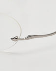 Close-up of For Art's Sake® Waver, featuring lightweight oval rimless glasses and a distinctively curved metallic silver temple arm, set against a white background.