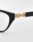 Close-up of The Act black cat-eye sunglasses by For Art's Sake®, showcasing a sculptural 3D weaved metal chain-link detail from the front frame to the temple, set against a plain white background.