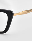 Close-up of For Art's Sake® Harmony(X) sunglasses with a thick black rectangular frame and shiny gold temple arms, set against a plain white background.