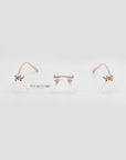 For Art's Sake® Ida eyeglasses feature a rimless, lightweight design with rose gold arms and butterfly accents on the lens corners, plus a subtle floral motif—all against a plain white background.