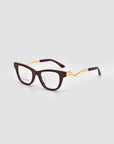 The For Art's Sake® Poppy eyeglasses feature dark, square frames with sculptural metal temples and gold accents, shown against a plain light gray background.