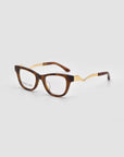 The For Art's Sake® Poppy eyeglasses feature a bold brown rectangular frame with striking gold zigzag arms, showcased on a plain light gray background.