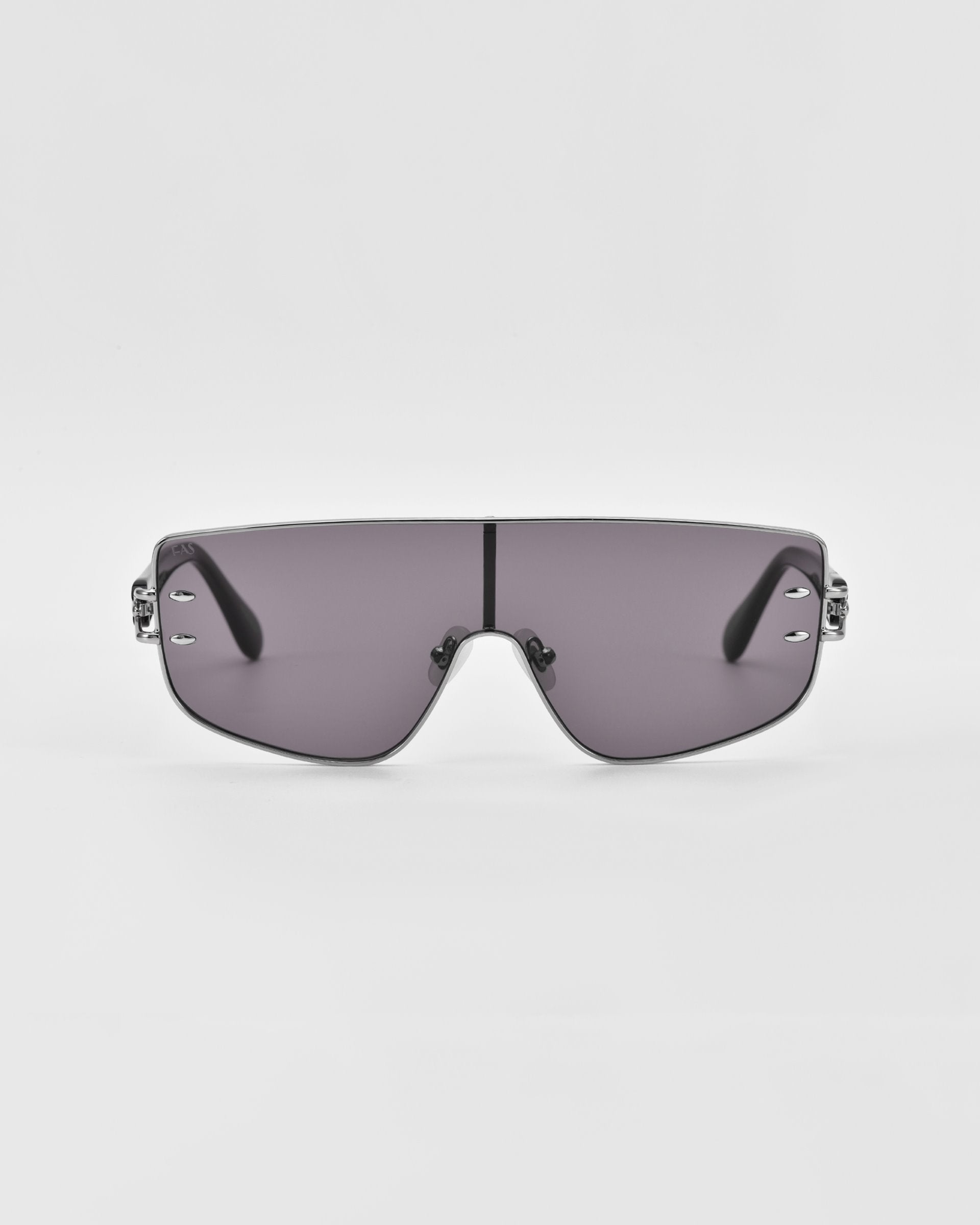 Introducing the Flare sunglasses by For Art's Sake®—a pair of futuristic-style luxury eyewear featuring a single, continuous gray-tinted lens and thin, black arms. The minimalistic nose bridge complements the sleek, slightly curved design of the lens. Set against a plain white background, these are the epitome of modern elegance.