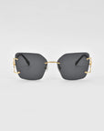 A pair of modern, oversized square lenses sunglasses with dark tinted lenses and gold-colored metal accents on the temples. The For Art's Sake® Starlit sunglasses feature jade-stone nosepads, and the minimalistic frame lacks a visible border around the lenses, creating a sleek and stylish design against a plain white background.