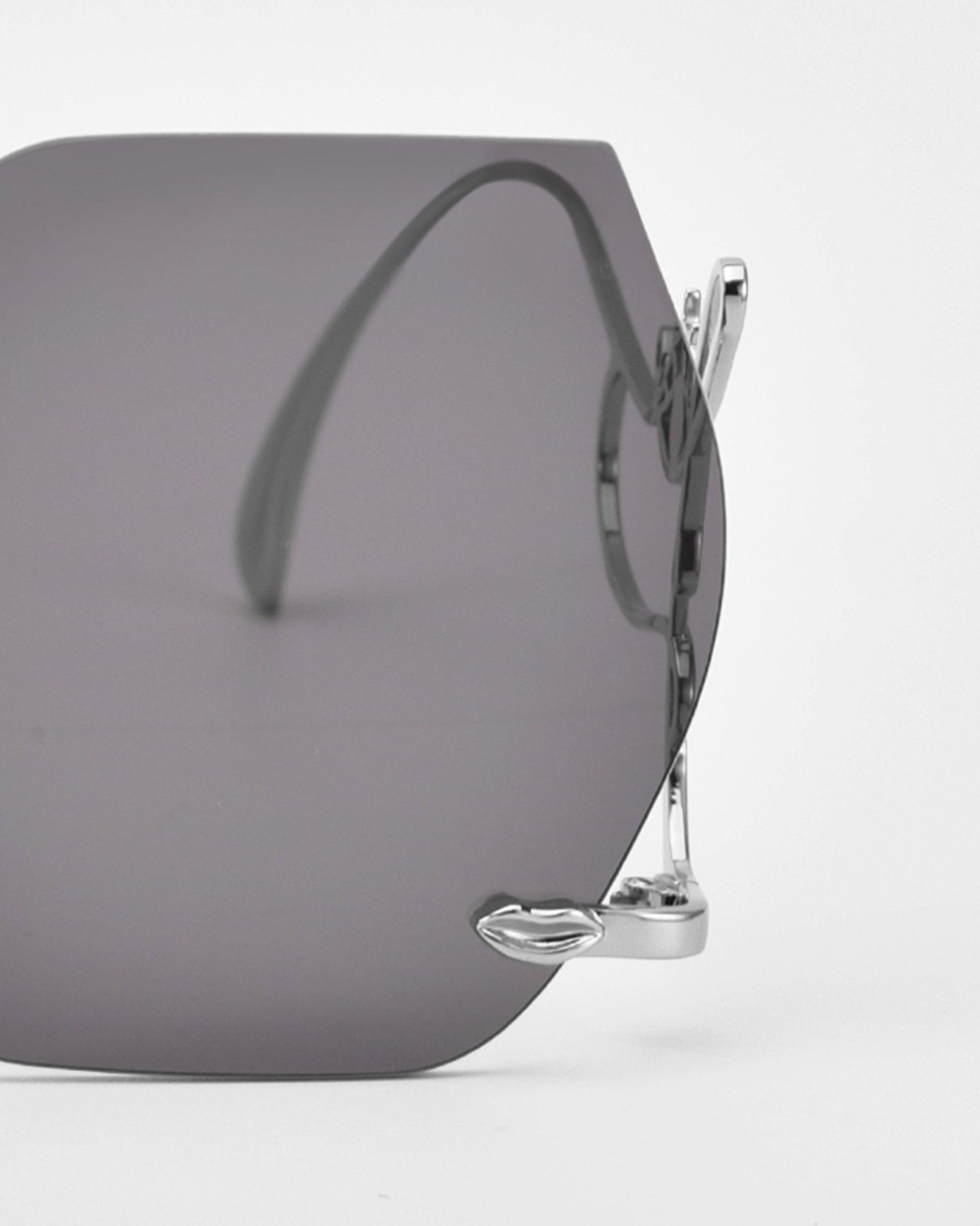 Close-up of For Art's Sake® "Cry Me a River" sunglasses, featuring bold, large dark square lenses and silver metal frames. Only part of these limited edition statement shades is shown against a white background.