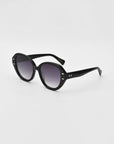 For Art's Sake® Mirage White: Black oval cat-eye sunglasses with dark gradient lenses, thick plant-based acetate frame, and small metallic studs near the hinges, shown on a plain white background.