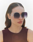 A model wearing the Sapphire sunglasses in Black. Showing off the large gradient frames with silver lining.