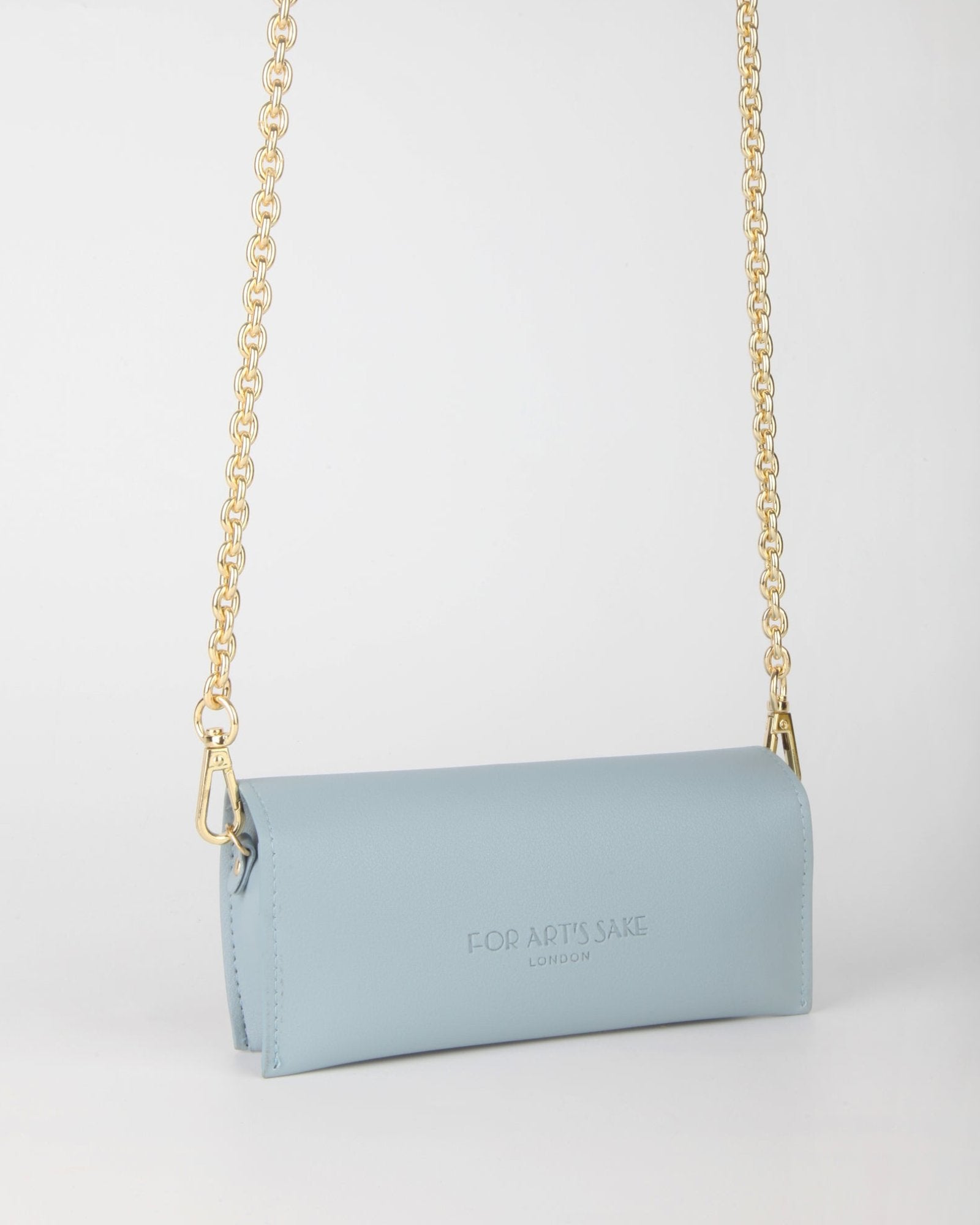 A small light blue rectangular handbag features a gold chain strap. The letters "F O R A P T 'S SAK E LONDON" are embossed on the front. The handbag is suspended against a plain white background.