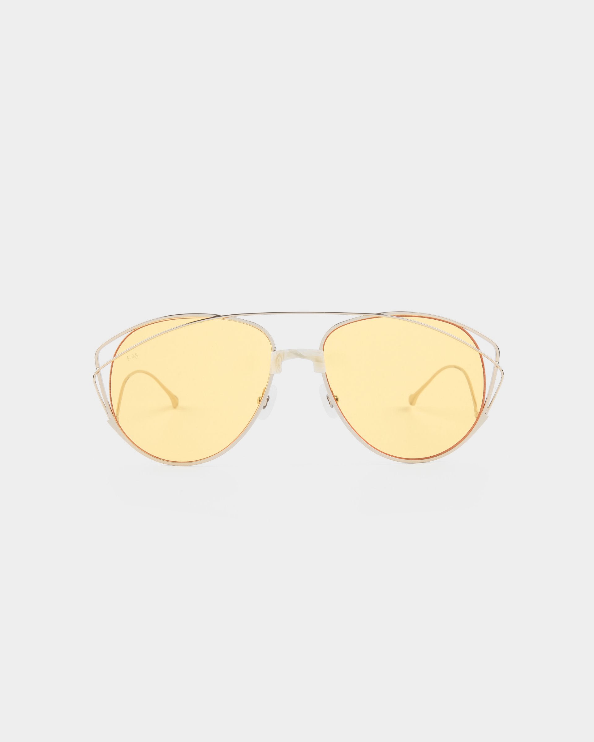 A pair of stylish For Art's Sake® Dark Eyes sunglasses with thin, stainless steel frames and yellow-tinted, nylon lenses. The design features a double bridge and sleek, minimalistic arms. Offering 100% UV protection, these sunglasses are set against a plain, white background.