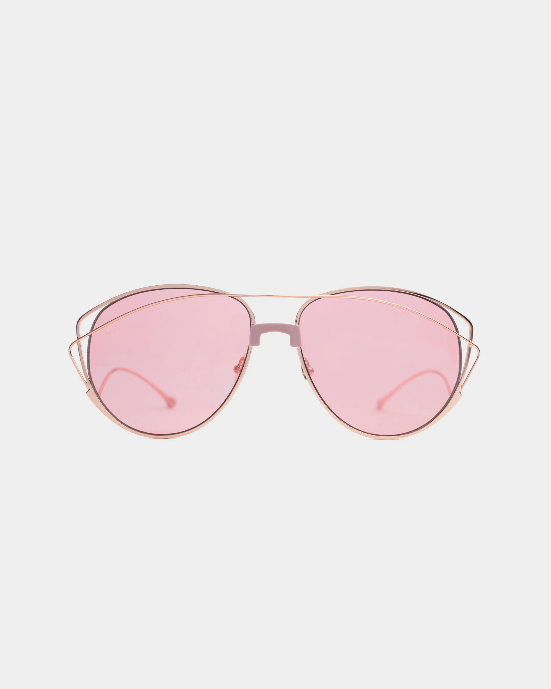 The Dark Eyes sunglasses by For Art's Sake® feature thin, stainless steel aviator-style frames and pink-tinted nylon lenses that provide 100% UV protection. The gold temples have a slight curve, and the nose pads are clear, all set against a plain white background.