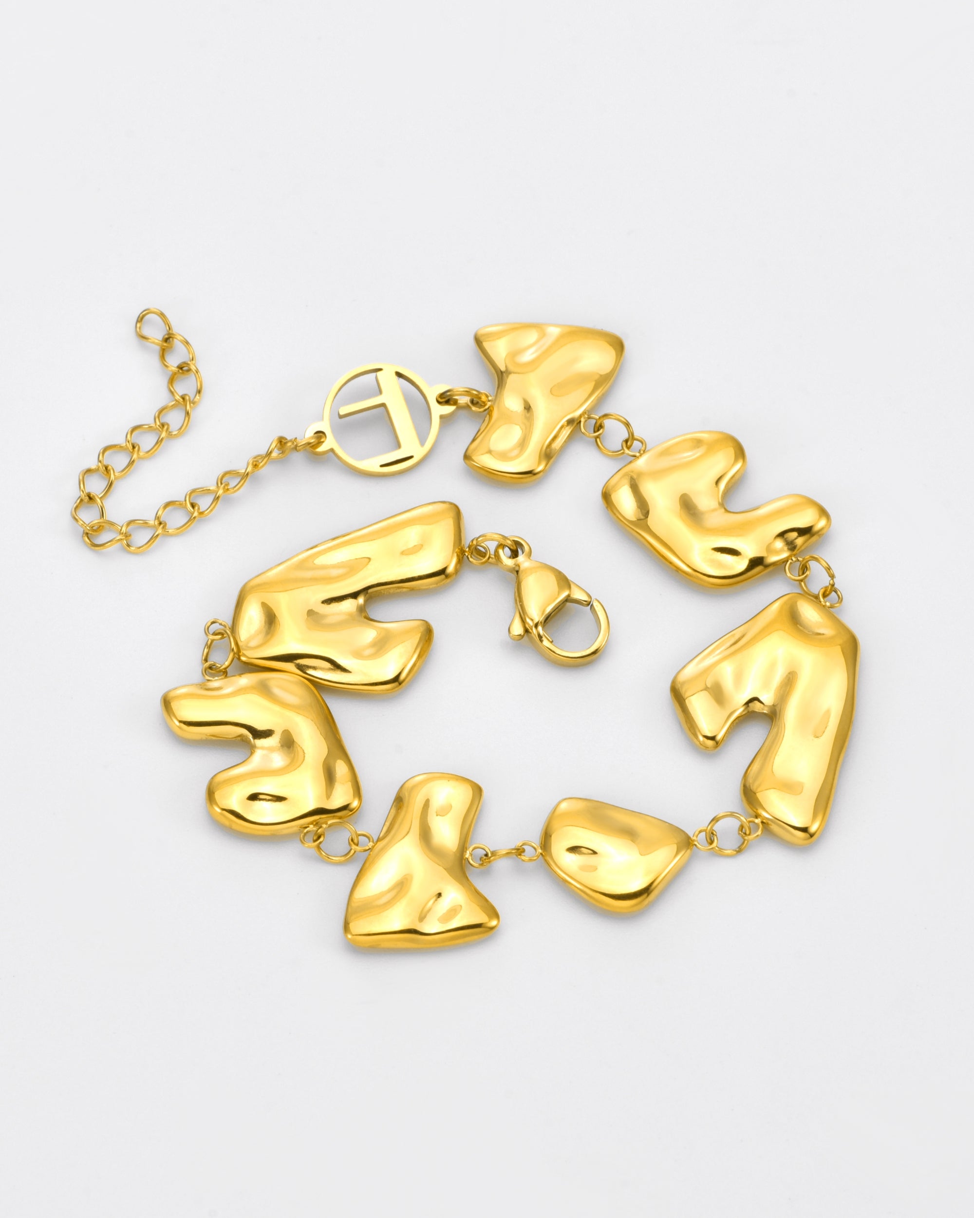 The Forms Bracelet by For Art's Sake® features irregular, abstract-shaped gold links joined by small rings, a lobster clasp, an adjustable chain, and a circular charm.