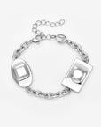 The Geometry Bracelet from For Art's Sake® is a silver chain with two large raised-design geometric charms—oval and rectangular—plus a lobster clasp, adjustable extender, and extra round charm for a modern touch.