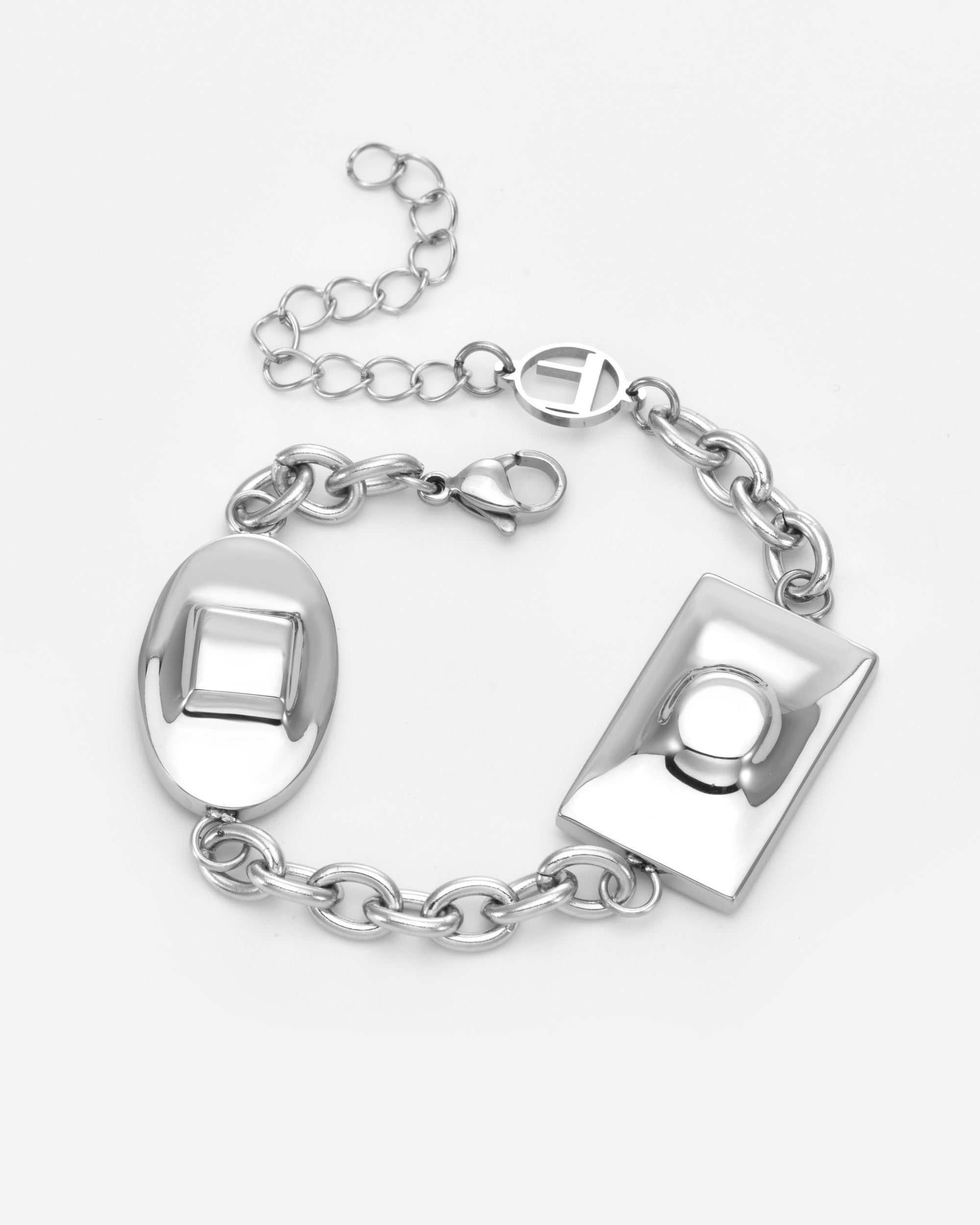 The Geometry Bracelet by For Art's Sake® is a modern silver chain bracelet with oval and rectangular geometric charms featuring raised designs, an adjustable extension chain, and a lobster clasp, shown on a plain white background.