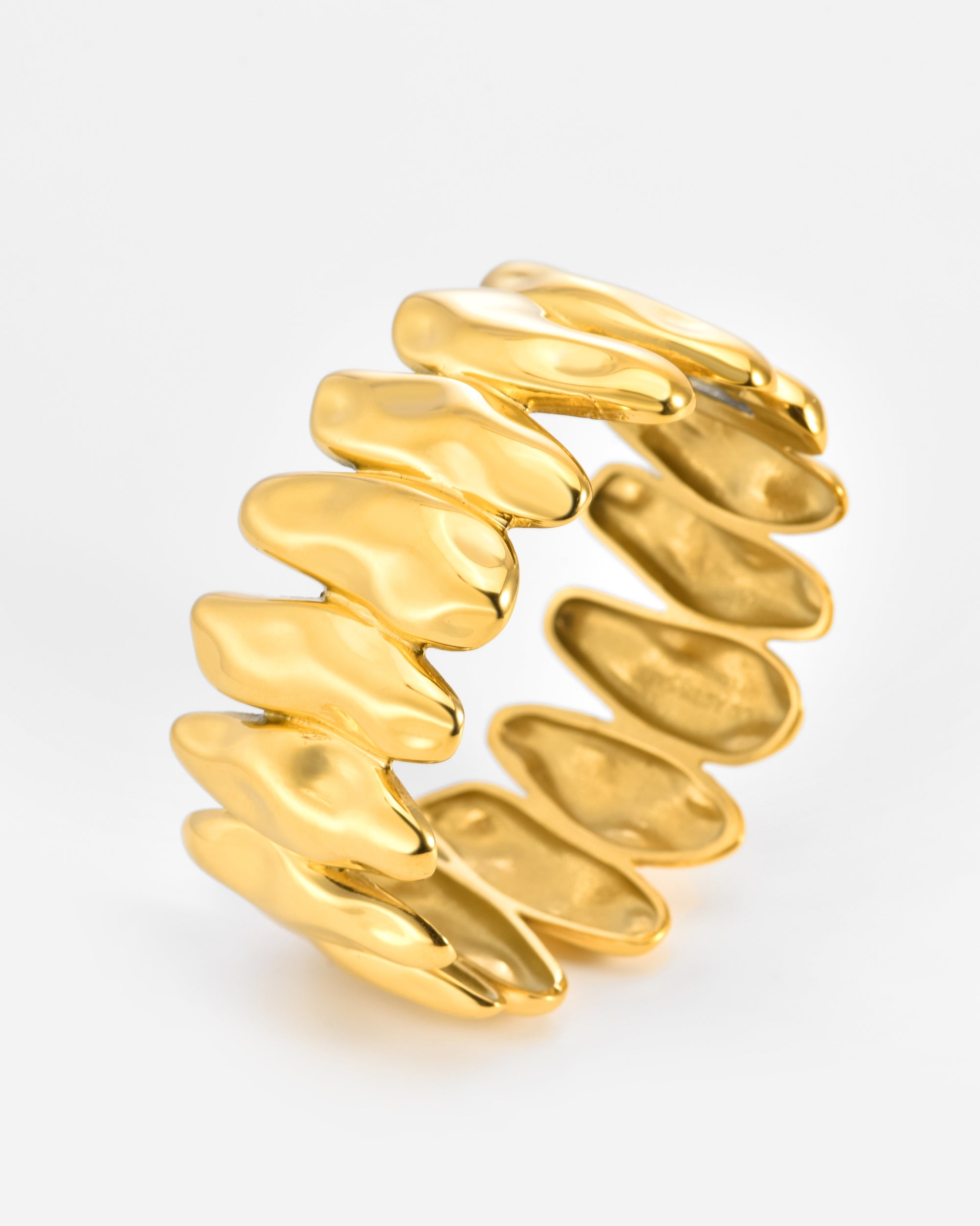 The Forms Bangle by For Art's Sake® features an open gold design with overlapping, irregular segments forming a wavy, textured pattern around the band. Displayed against a white background.