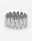 The Forms Bangle by For Art's Sake® is a silver organic metal ring with an irregular design and smooth, rounded shapes linked in a continuous band, displayed on a plain white background.