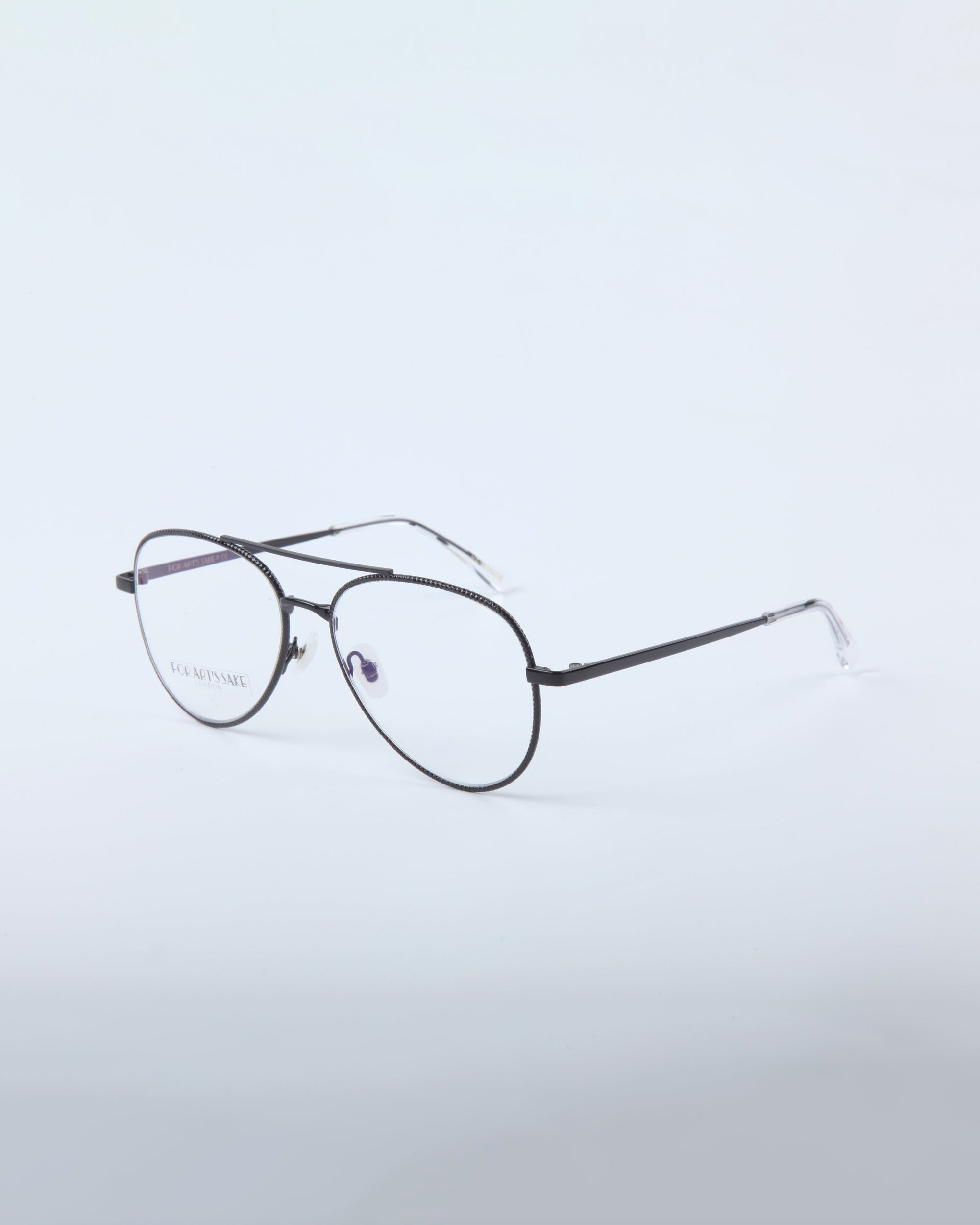 For Art's Sake® Cleo: Black round metal eyeglasses with clear nose pads and transparent temple tips on a light gray background. Final sale—no returns or reselling allowed.