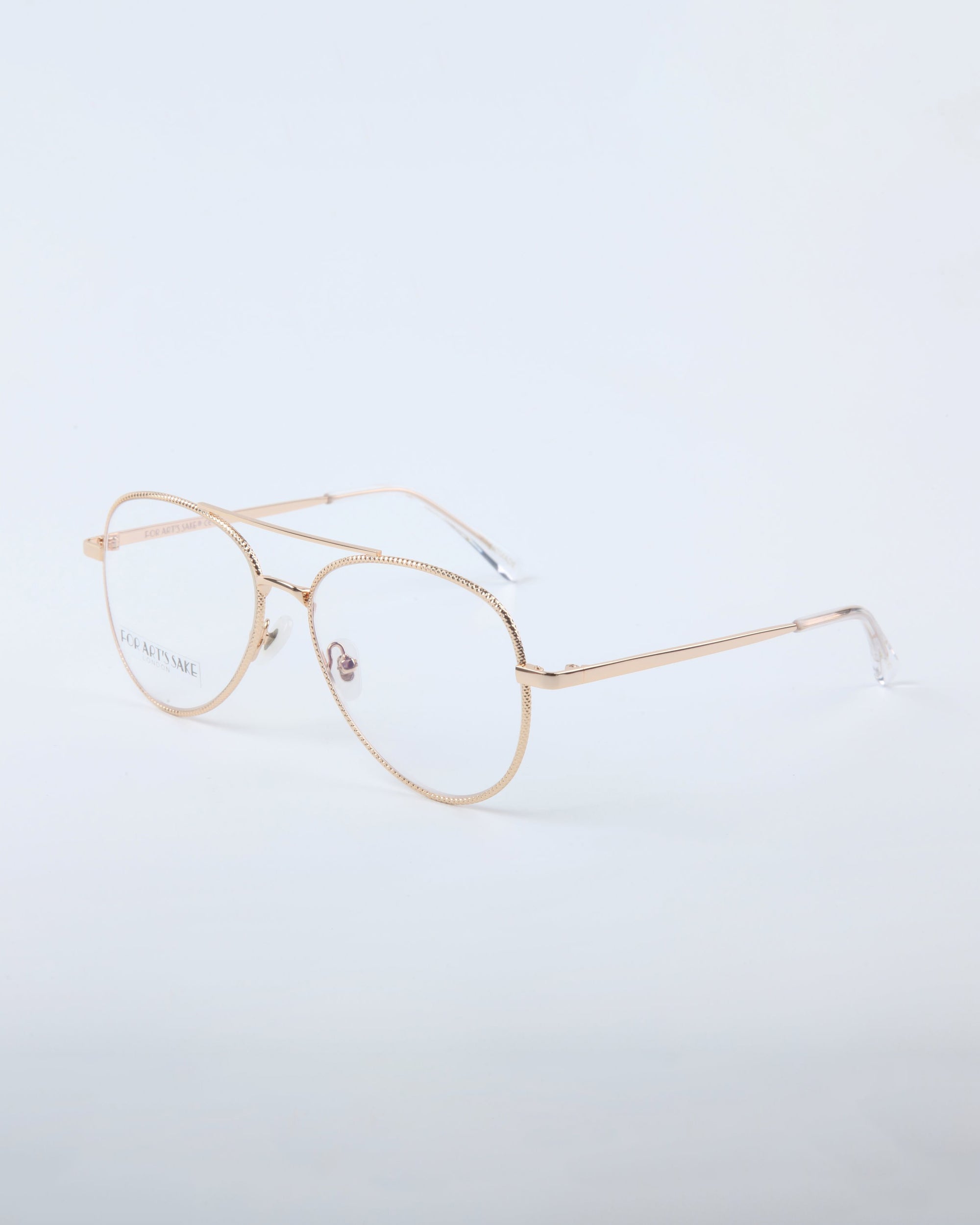 The Cleo eyeglasses by For Art's Sake® feature stylish gold rims and clear lenses, shown on a plain white background. Final sale only.