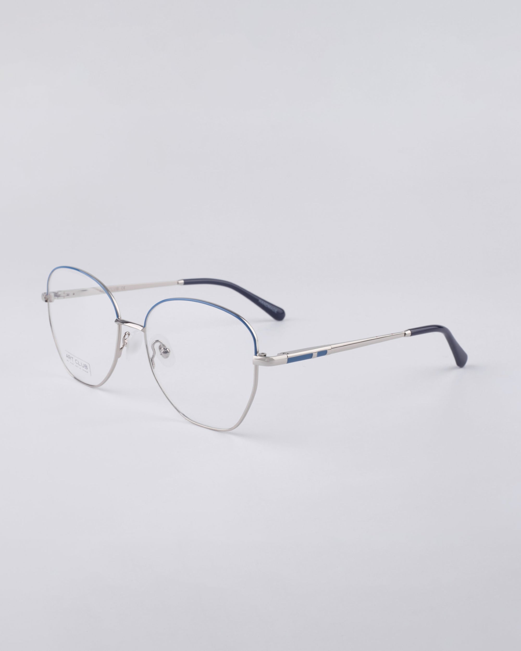 For Art's Sake® Coco: Silver stainless steel frames with rounded rims, thin temples, subtle blue accents on the top frame and tips, and jade nose pads for comfort—all shown on a light gray background.
