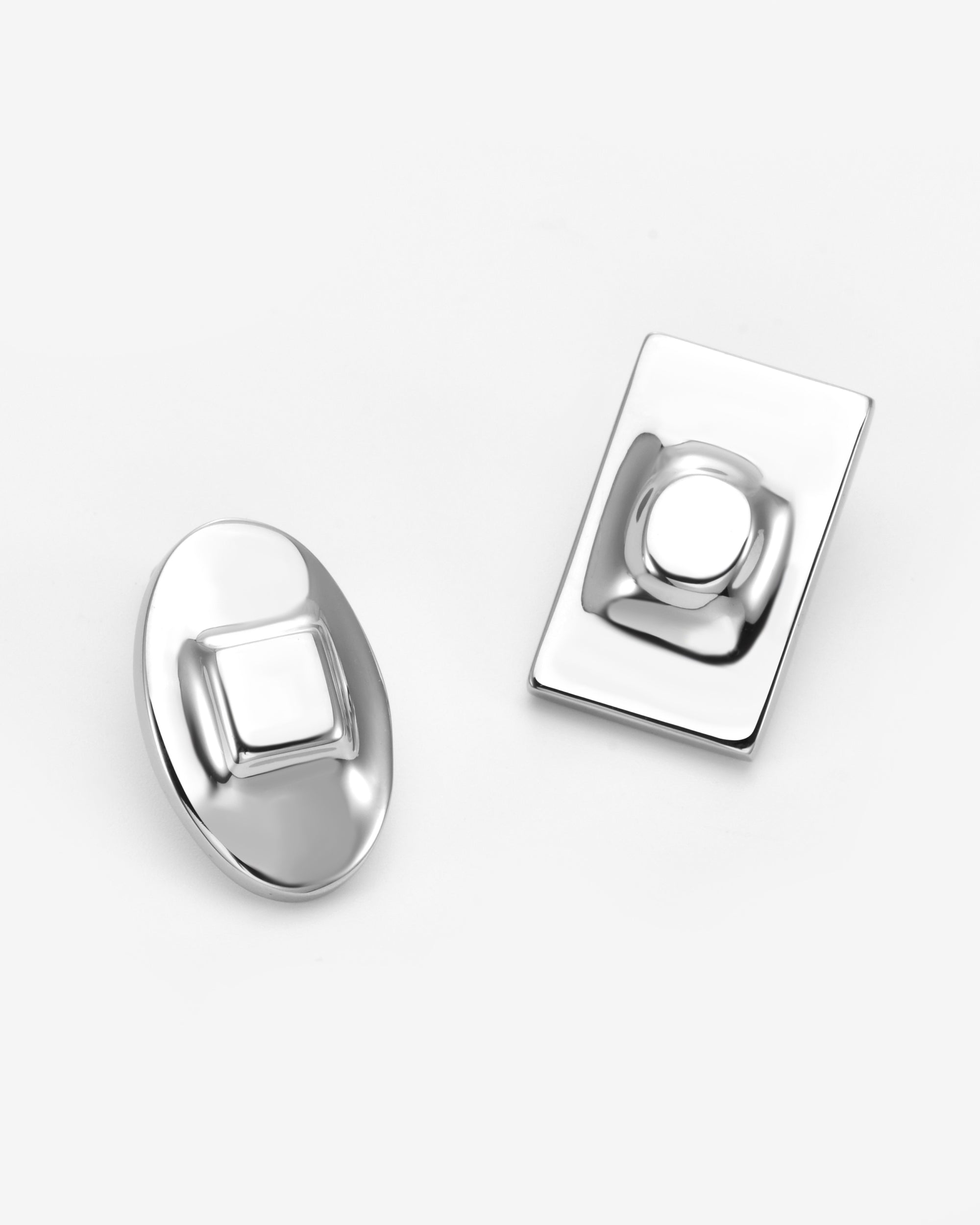 Showcasing The Geometry Earrings by For Art's Sake®: an oval piece with a raised square center and a rectangle with a raised circle, these silver minimalist earrings add modern, geometric flair to any look.