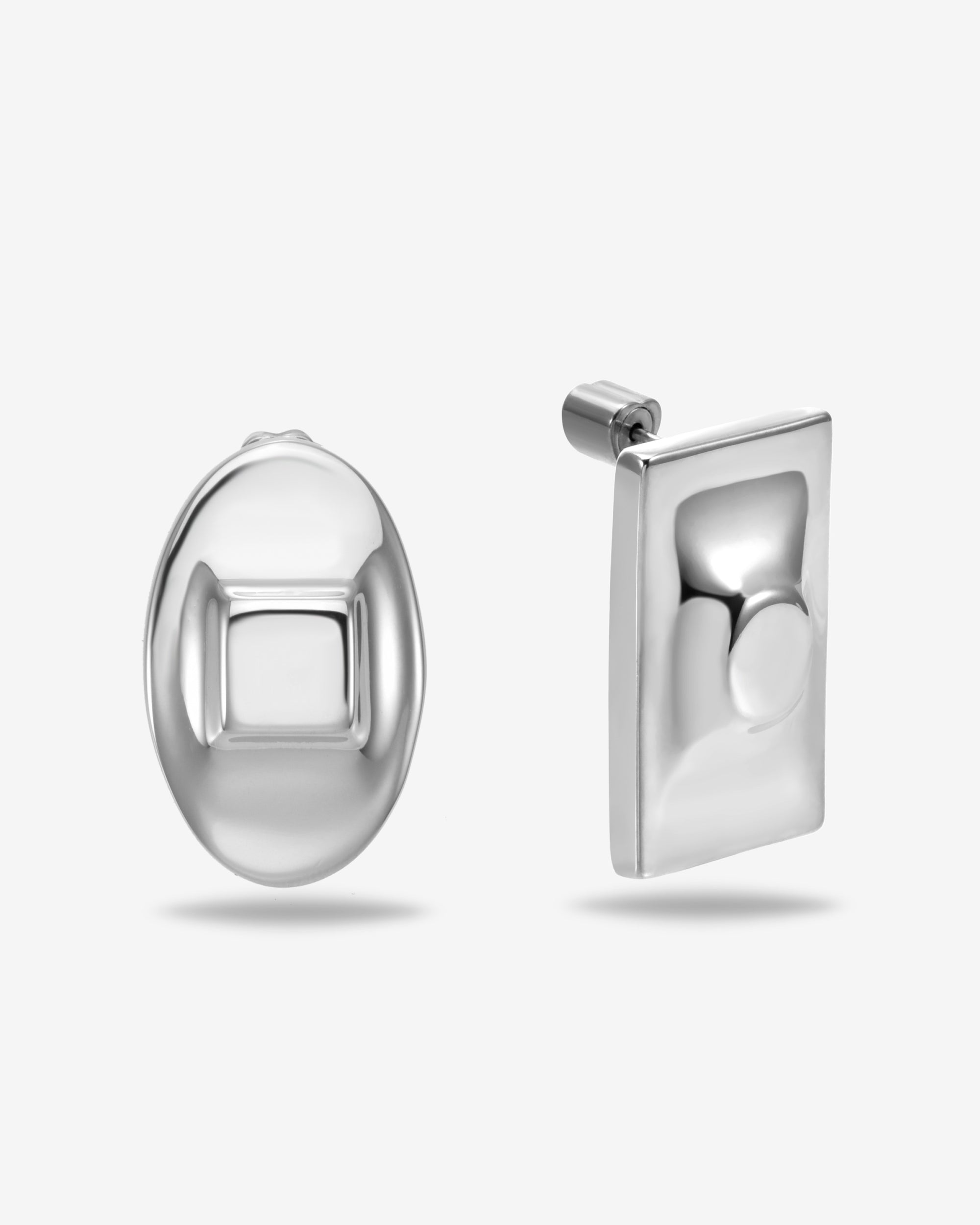 The Geometry Earrings by For Art's Sake® feature a modern, minimalist pair: one oval stud with a raised square center and one rectangular earring with a raised circle, shown on a plain white background.
