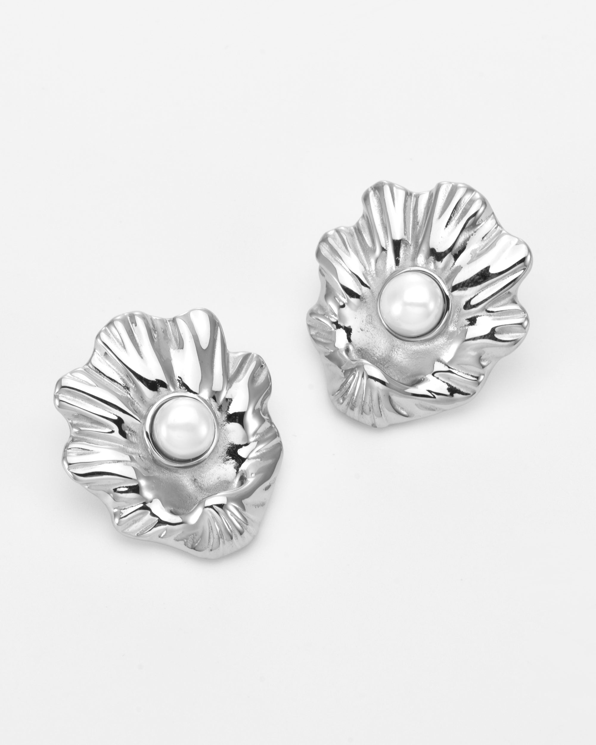 The Shell Earrings by For Art's Sake® feature silver sea shells with a ruffled texture and a central round freshwater pearl—an elegant choice for everyday wear, shown against a white background.