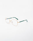A pair of Grace prescription glasses from For Art's Sake® with an 18-karat gold-plated metal frame and green temples. The clear lenses feature a Blue Light Filter, and the glasses are positioned at an angle on a plain white background. The brand name "For Art's Sake®" is visible on the left lens.