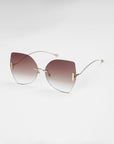 Introducing the Starlight sunglasses by For Art's Sake®—a pair of stylish shades featuring large, gradient lenses that transition from dark at the top to lighter at the bottom. These rimless lenses are connected by thin, gold-colored wireframes and include Jadestone nose pads, offering both a sleek look and enhanced comfort against a plain white background.