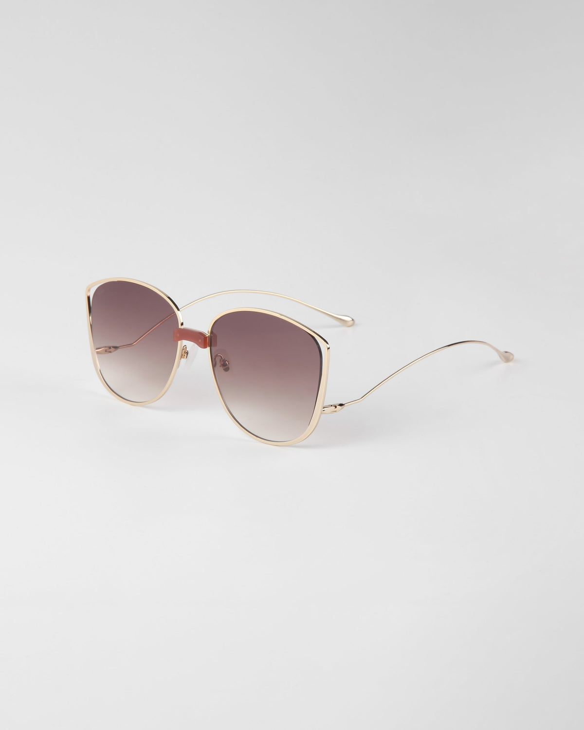 A pair of Spacie sunglasses from For Art's Sake® featuring handmade 18-karat gold plating on a white background.