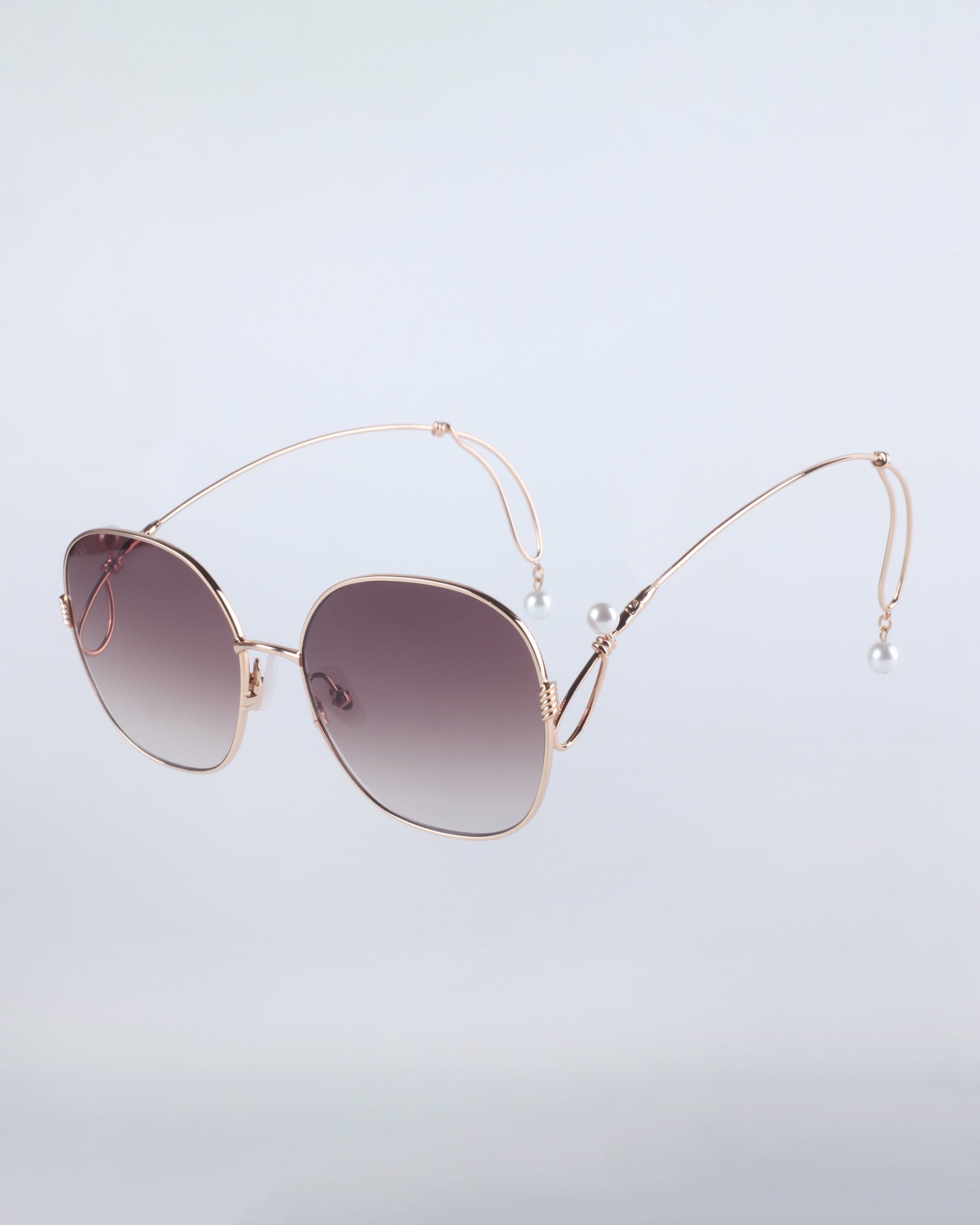 For Art's Sake® Lemonade features large square sunglasses with thin gold wire frames, gradient dark lenses, and uniquely curved arms finished with faux-pearl tips, set against a light gray background.