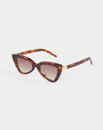 Introducing the Mad Mad sunglasses by For Art's Sake®: a pair of stylish cat-eye sunglasses featuring UVB-protected tortoiseshell acetate frames and brown gradient lenses. The sleek arms are also tortoiseshell and adorned with a small gold accent on each side. The sunglasses are elegantly presented against a plain white background.