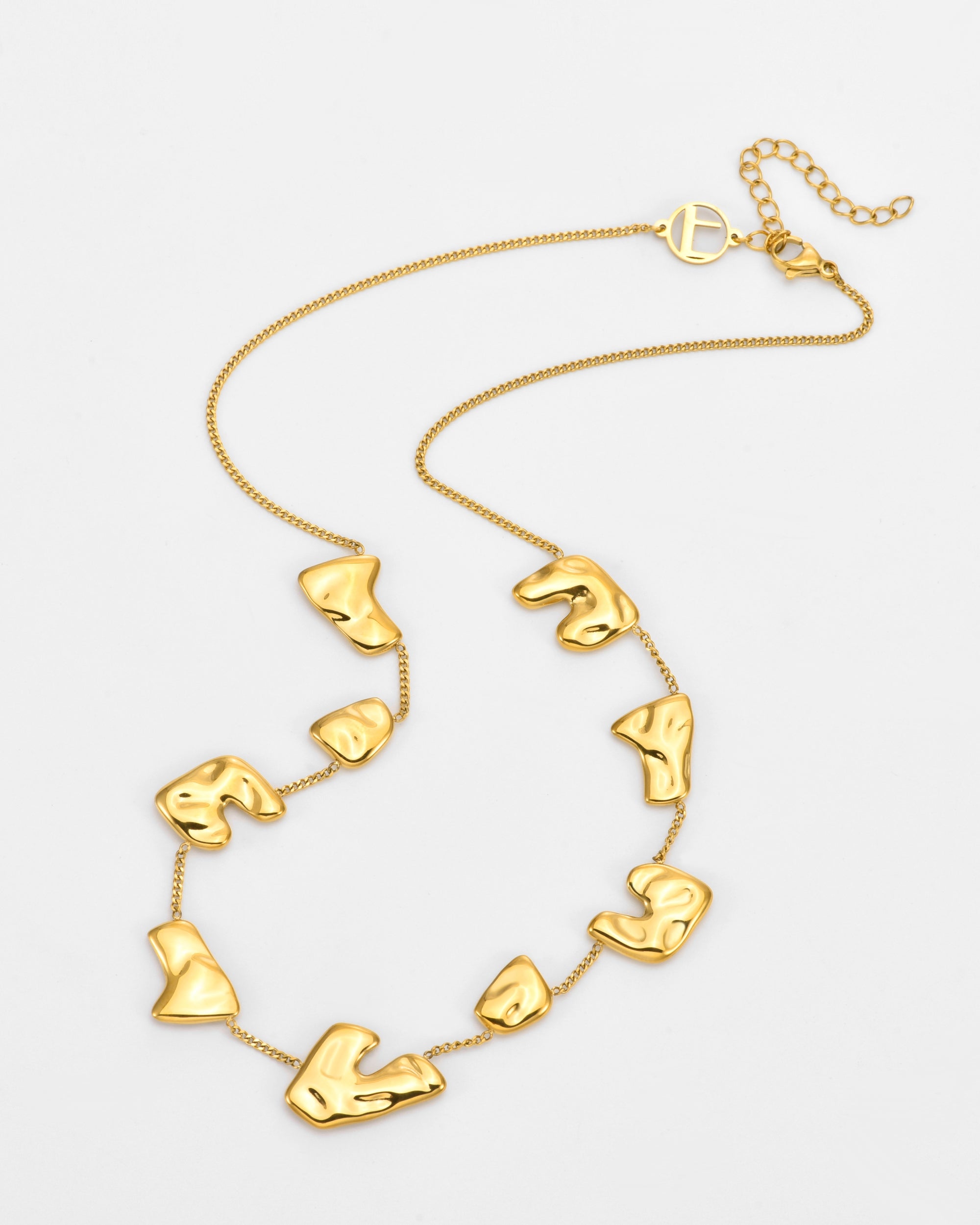 The Forms Necklace by For Art's Sake® features an adjustable gold chain with a toggle clasp and several polished, irregular gold pendants. It is shown against a plain white background.