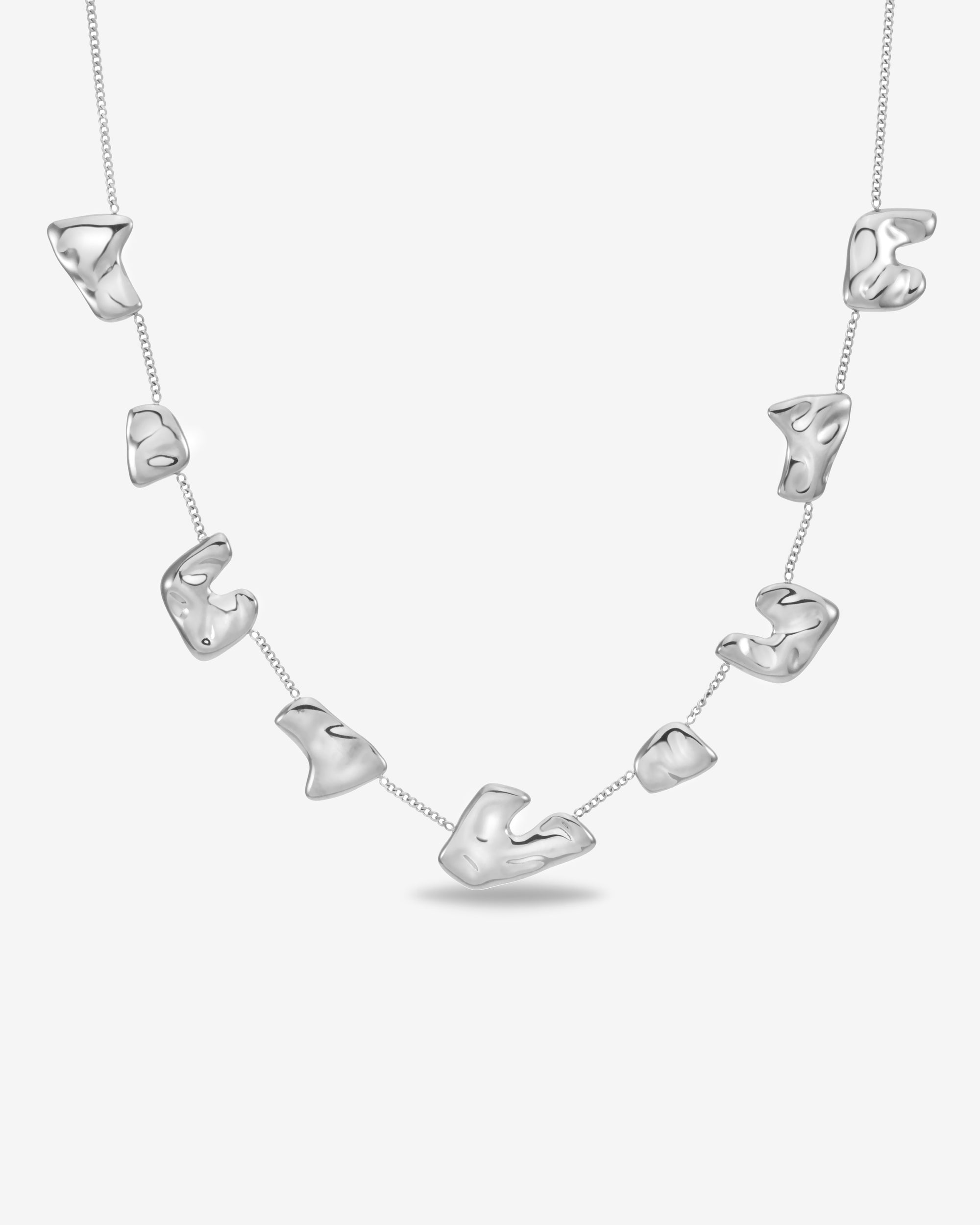 The Forms Necklace by For Art's Sake® features seven irregular, organic metal charms evenly spaced on a delicate silver chain, displayed against a plain white background.