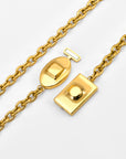 A close-up of The Geometry Necklace by For Art's Sake®, featuring a gold chain and distinctive rectangular and oval clasp, displayed open against a white background.