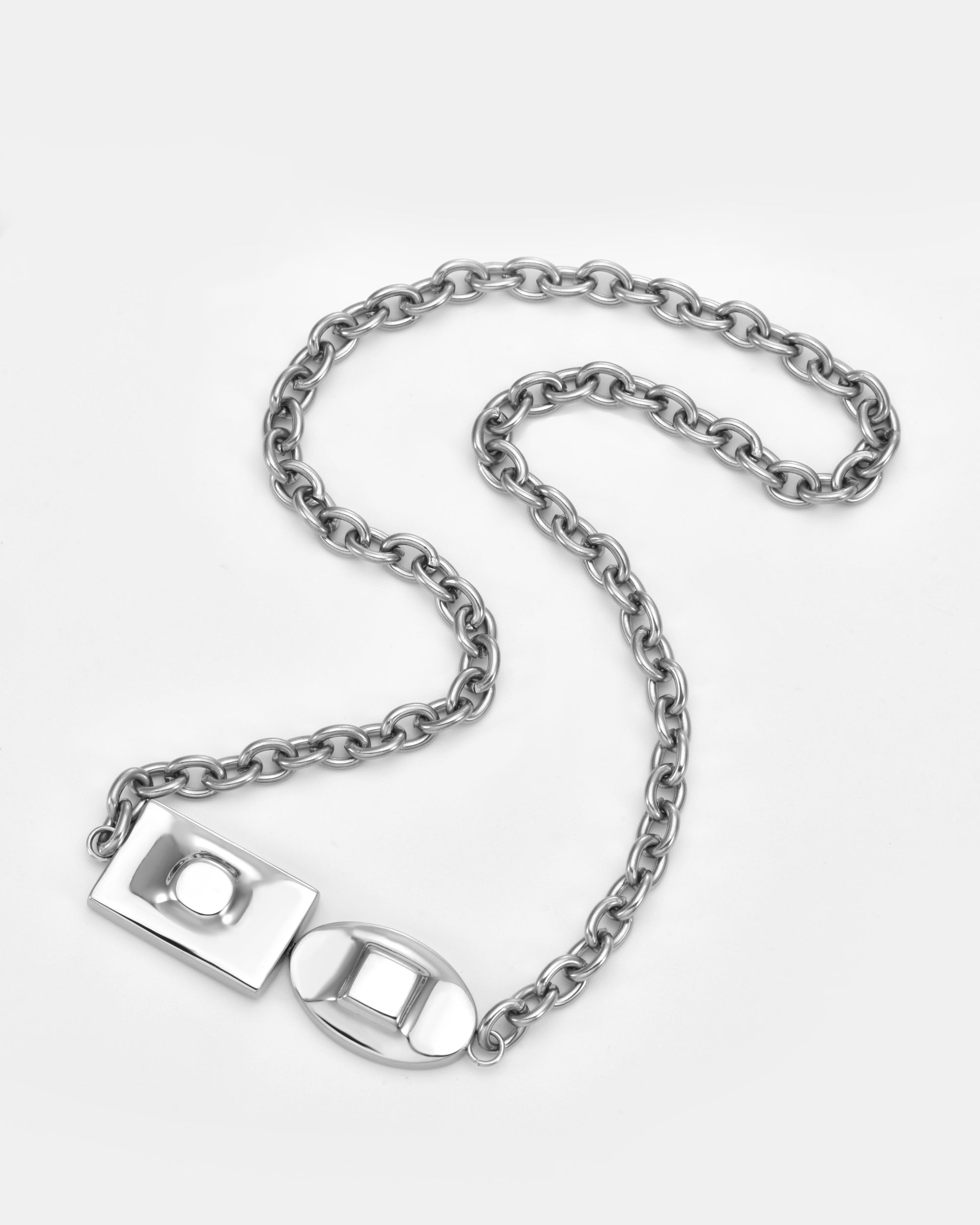 The Geometry Necklace by For Art's Sake® features large, rounded silver links and a unique geometric clasp with rectangular and oval shapes, showcased on a plain white background.