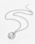 The Shell Pendant by For Art's Sake® is a silver necklace with a delicate chain and an abstract, flower-shaped charm with a white freshwater pearl—perfect for subtle coastal elegance. Shown on a plain white background.