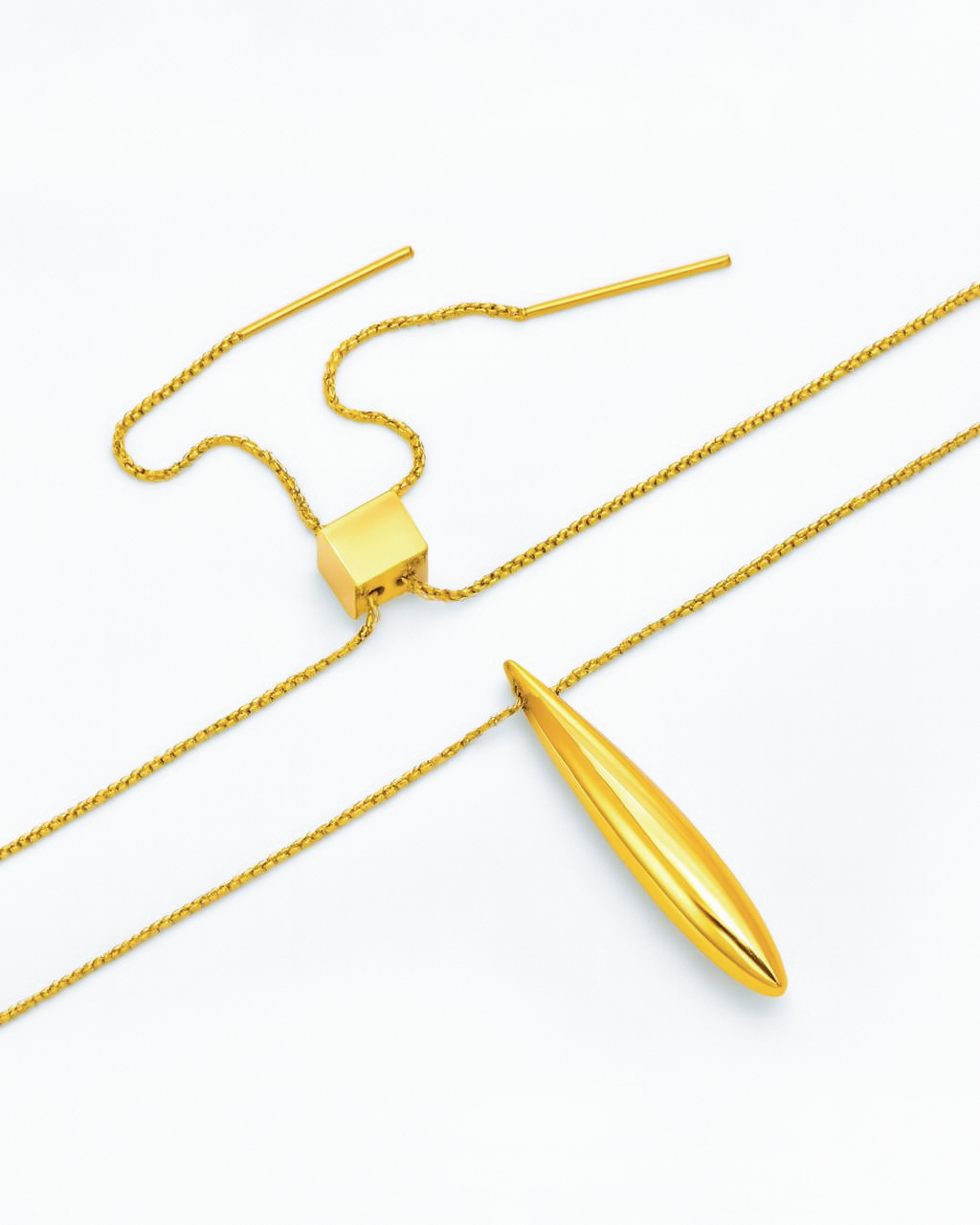 The Droplets Pendant Necklace by For Art's Sake® is a minimalist gold piece with a sleek, elongated droplet pendant and adjustable slider clasp, shown on a white background.