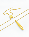 The Droplets Pendant Necklace by For Art's Sake® is a minimalist gold piece with a sleek, elongated droplet pendant and adjustable slider clasp, shown on a white background.