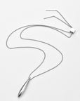 The Droplets Pendant Necklace by For Art's Sake® features a sleek, elongated metal droplet on a delicate chain with adjustable straight bar ends, shown elegantly against a white background.