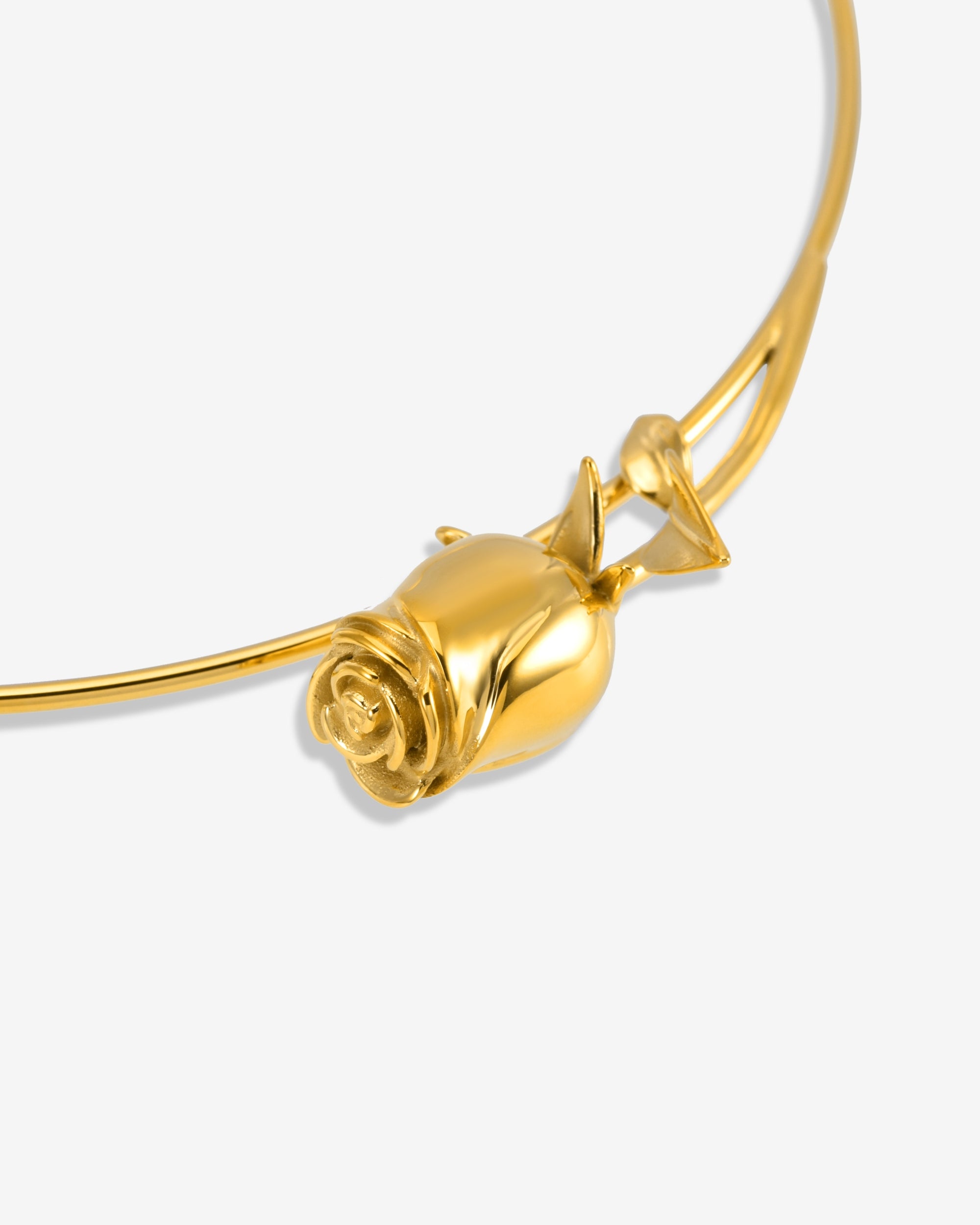 The Rose Choker by For Art’s Sake® showcases a detailed rose-shaped gold pendant on a sleek curved band, captured up close against a plain white background.