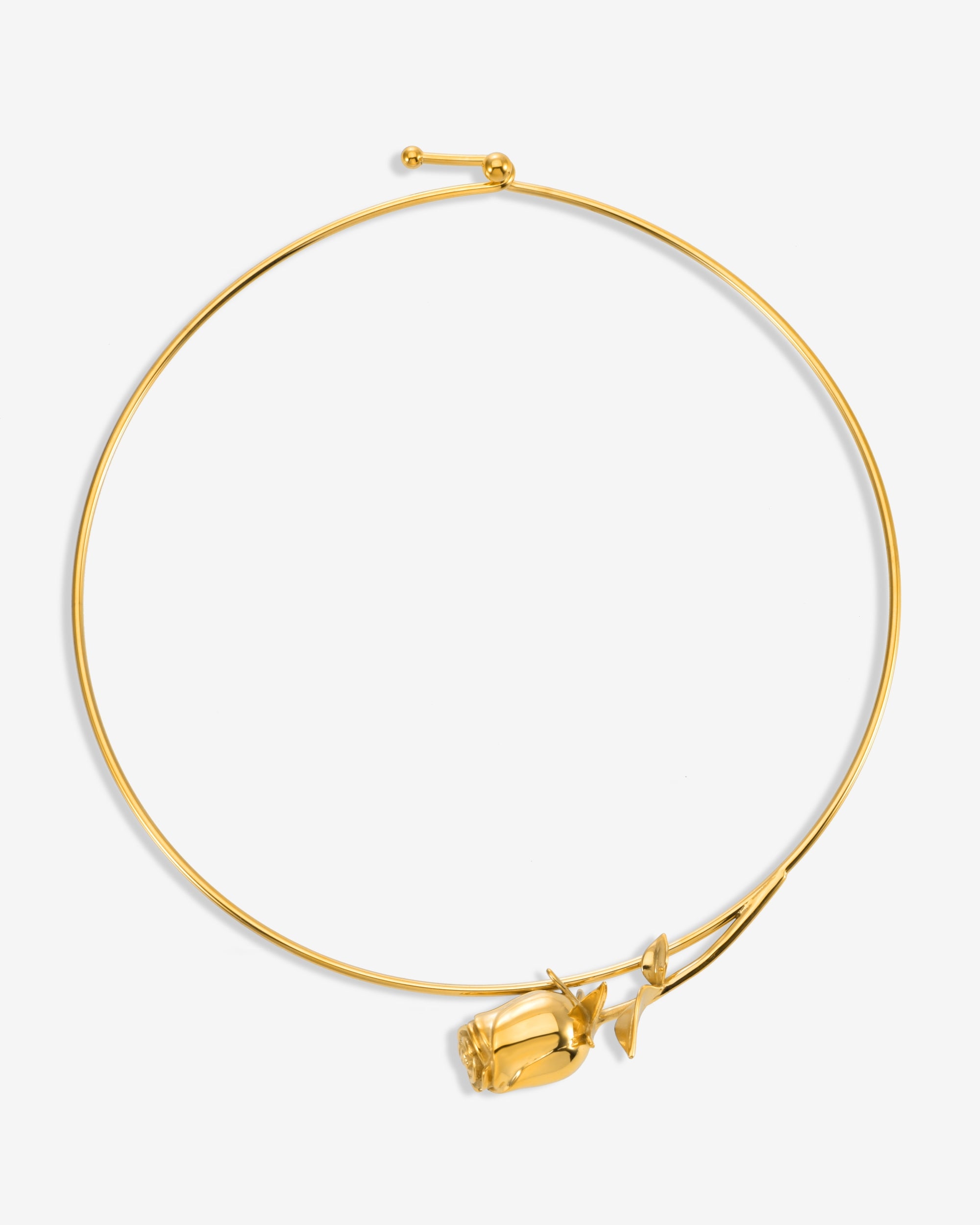 The Rose Choker by For Art's Sake® is a slim gold necklace with an intricate rose and leaf detail near the clasp, shown on a plain white background.