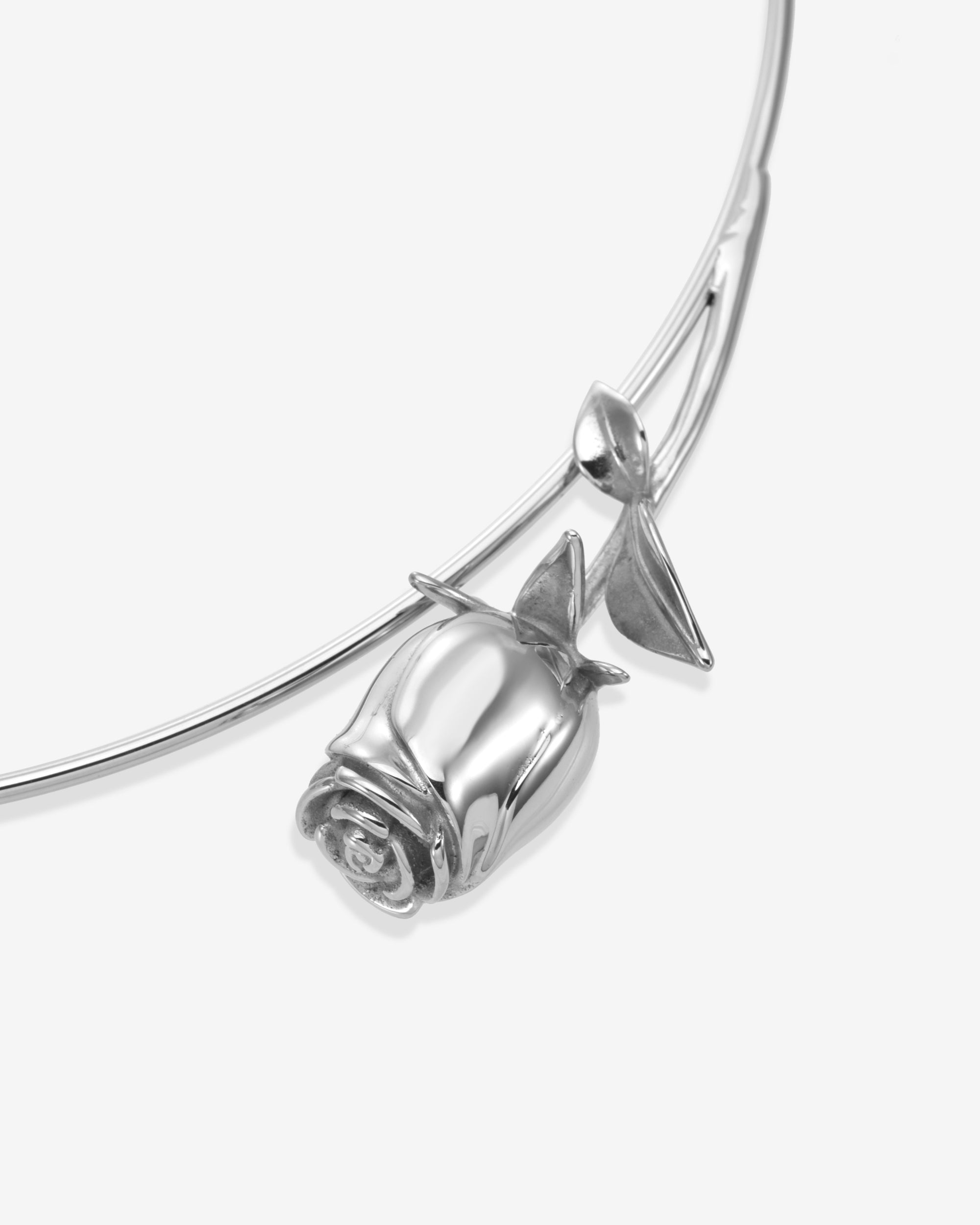 The Rose Choker by For Art's Sake® is a modern necklace featuring a sculpted rose pendant with two leaves, shown in close-up against a plain white background.