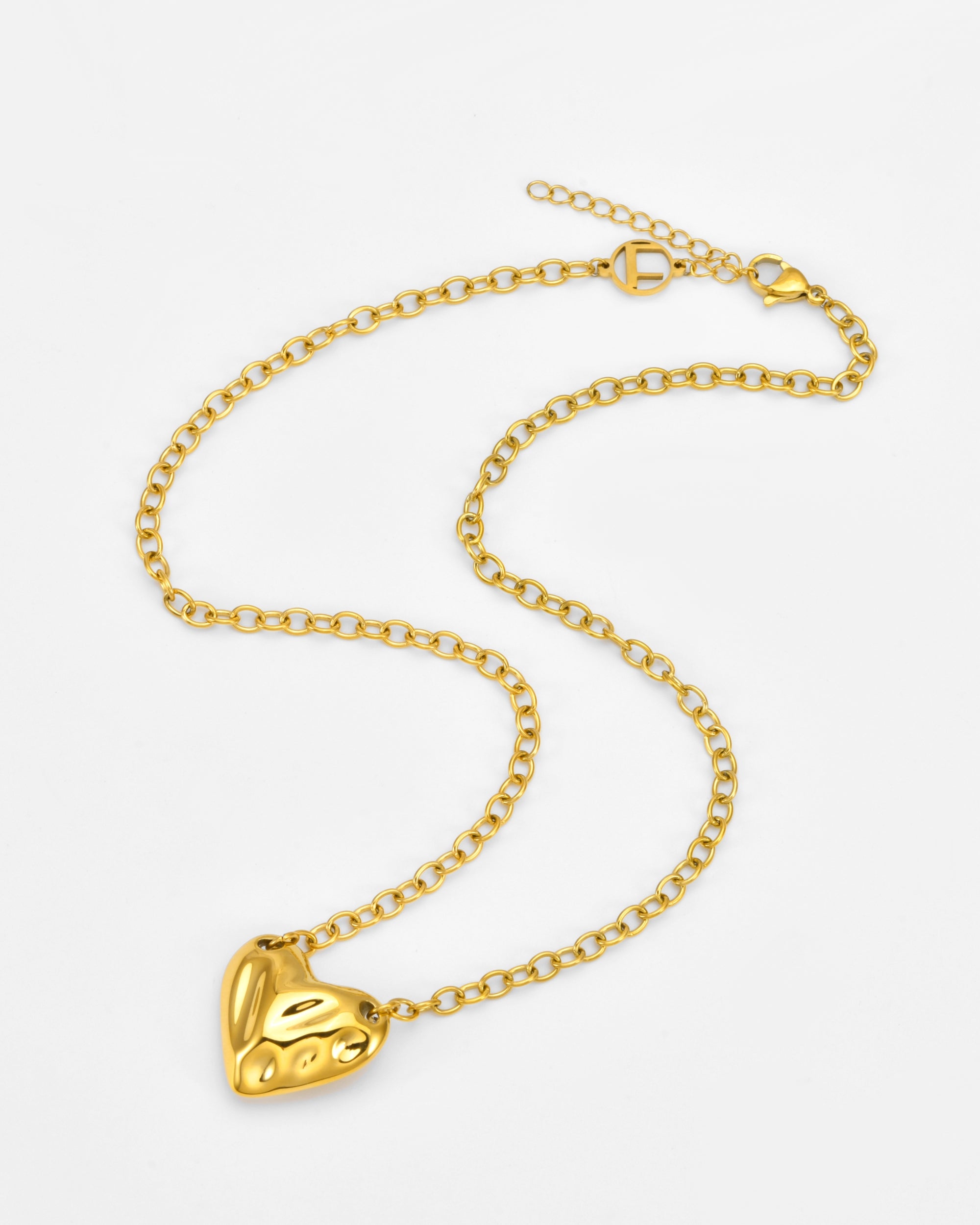 The Sculpted Heart Necklace by For Art's Sake® features a gold chain with an adjustable clasp and a shiny, heart-shaped pendant with subtle sculpted details, displayed on a white background.
