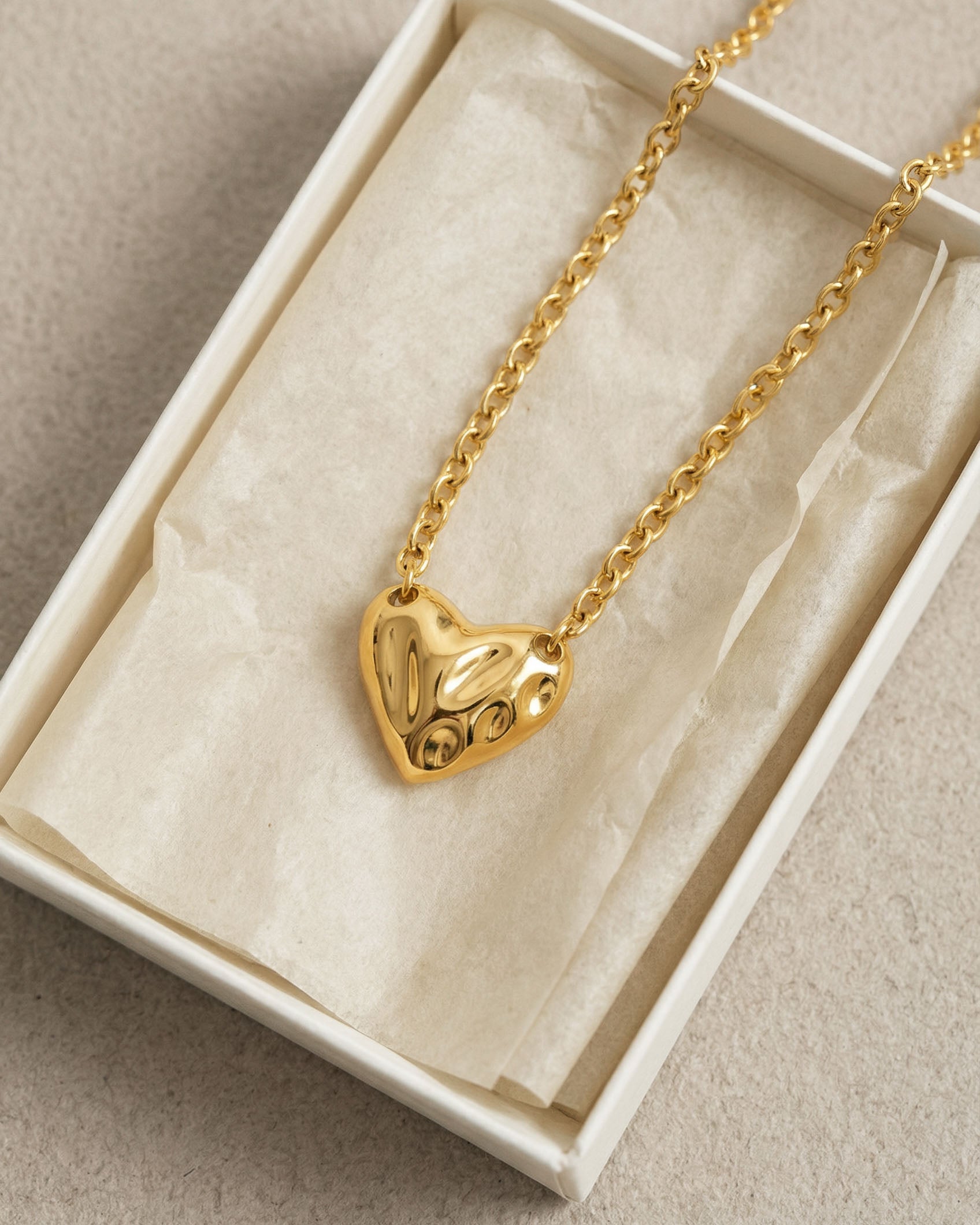 The Sculpted Heart Necklace by For Art's Sake® features an abstract, textured heart pendant on a delicate chain, presented in a white jewelry box with cream tissue. Perfect for everyday wear.