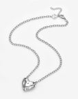The Sculpted Heart Necklace by For Art's Sake® features a shiny, sculptural heart pendant on a delicate silver chain, displayed against a white background.