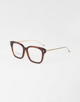 A pair of eyeglasses named Florence by For Art's Sake® featuring a plant-based acetate tortoiseshell-pattern frame with gold metal temples. The rectangular lenses offer UV protection, with "F.C.C. ARTWEAR" displayed on the inner side of the left lens, set against a plain white background.