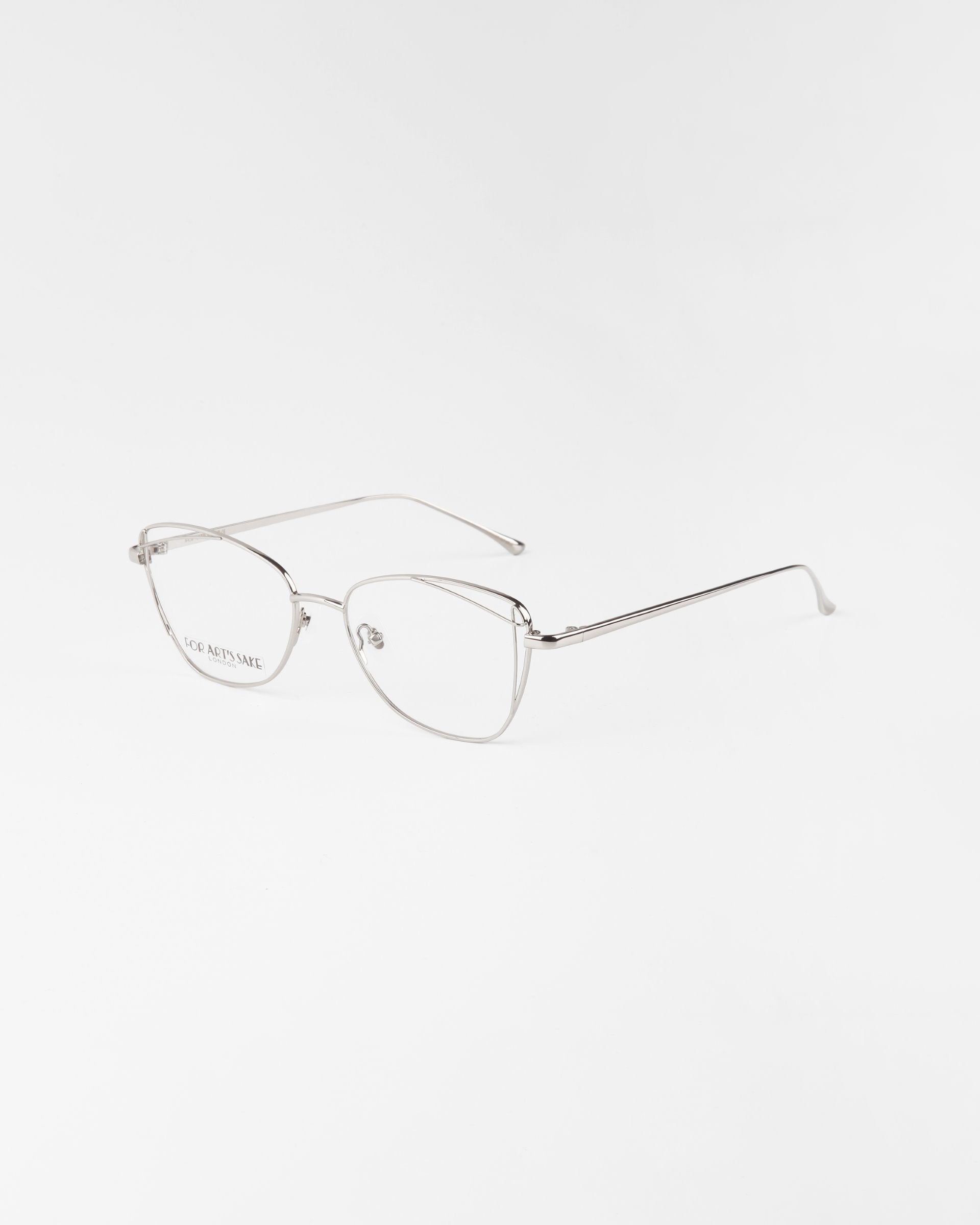 The Twist eyeglasses by For Art's Sake® feature thin, angular silver stainless steel frames and minimalist arms. With clear lenses and optional blue light filter, these modern glasses provide a lightweight, stylish look on any surface.