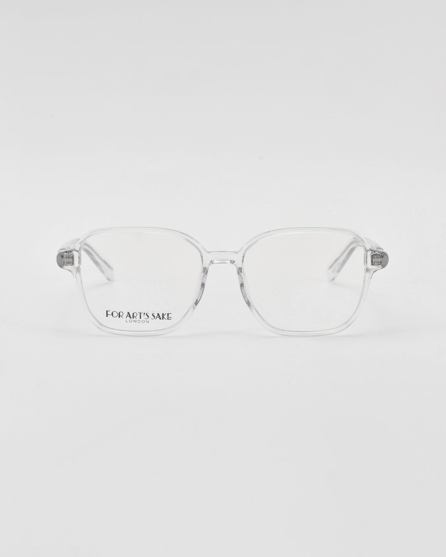 A pair of For Art's Sake® Charm transparent framed optical glasses in a cat-eye shape on a white background, with a visible brand name etched on one lens.