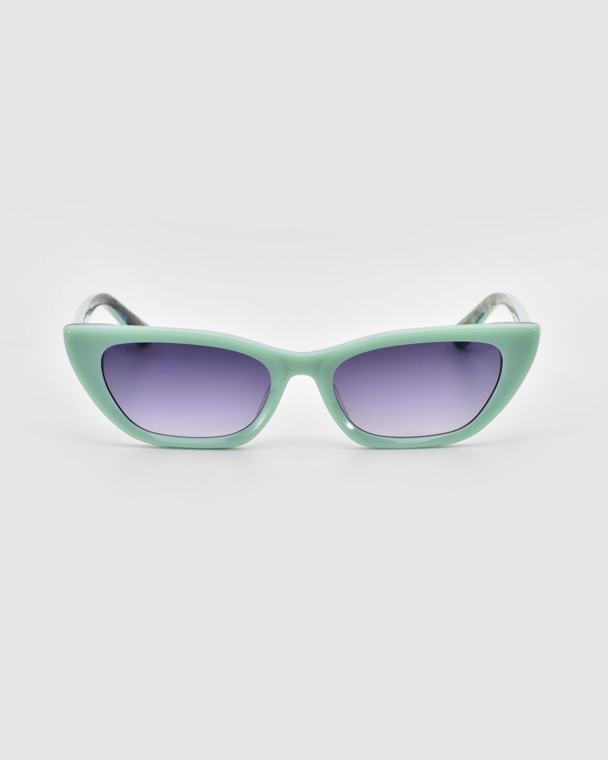 For Art's Sake® Claude Monet: mint green cat-eye sunglasses with purple-tinted lenses, shown on a plain light gray background.