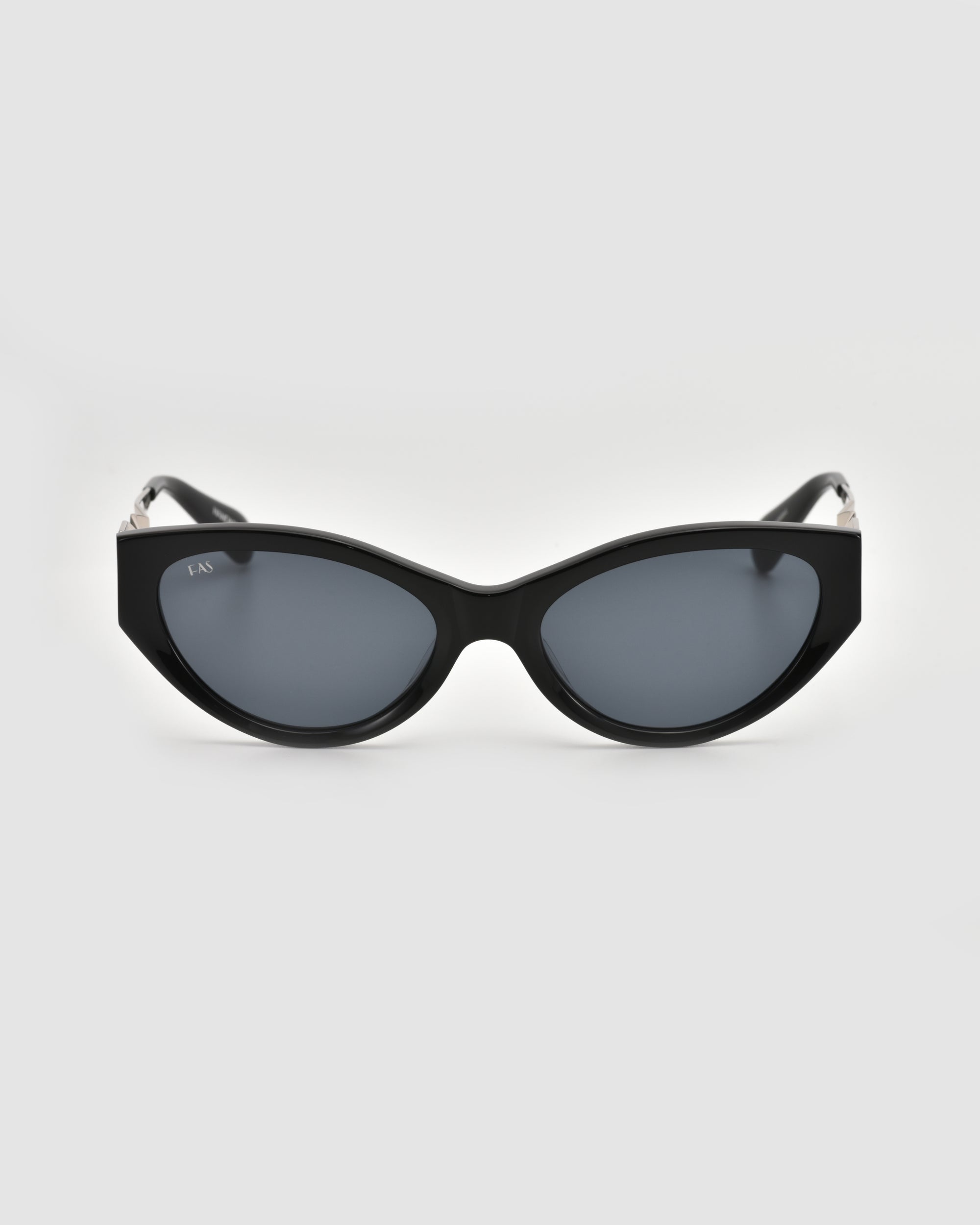 For Art's Sake® Unfold sunglasses: black cat-eye frames with dark tinted lenses and a sculptural silhouette, shown front-facing against a plain light gray background.
