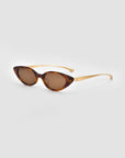 For Art's Sake® Slash cat-eye sunglasses with brown-tinted lenses and a tortoiseshell frame, sculptural curved arms, shown on a light grey background.